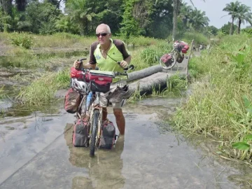 Pat pushing his bicycle through water