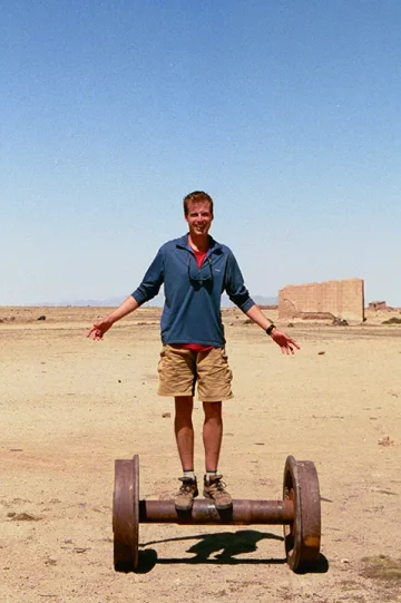 Scott balancing atop train wheels Bolivia